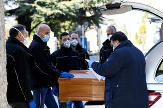 Homens com máscaras de protenção pegam caixam de pessoa morta pelo coronavírus em cemitério em Bérgamo, na Itália
16/03/2020
REUTERS/Flavio Lo Scalzo
