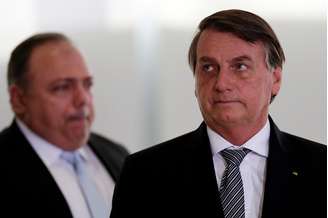 Bolsonaro, com Pazuello ao fundo no Palácio do Planalto
 8/12/2020 REUTERS/Ueslei Marcelino