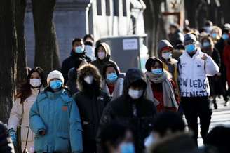 Pessoas usando máscara de proteção caminham em Pequim, na China. 16/1/2021. REUTERS/Tingshu Wang