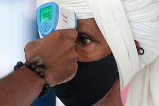Profissional de saúde mede temperatura de passageiro em estação ferroviária em Mumbai, na Índia
21/03/2021 REUTERS/Francis Mascarenhas