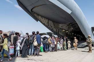 Afegãos embarcam para deixar o país no aeroporto Hamid Karzai. 21/8/2021. Air Force/Senior Airman Brennen Lege/Handout via REUTERS 