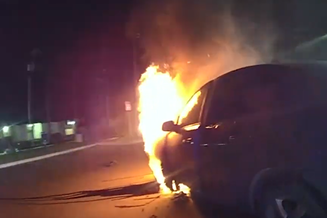 Um vídeo mostra policiais entrando em ação para salvar uma mulher inconsciente que estava presa em um carro em chamas