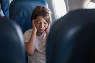 Dores de ouvidos durante o voo são comuns tanto em adultos quanto em crianças. (Fonte: Getty Images)