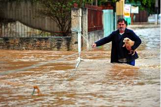 Homem resgatando um cachorro na inundação