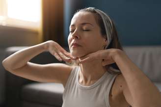 Mulher massageando o pescoço.