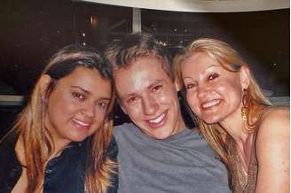 Preta Gil e Felipe Suhre posam ao lado de mulher loira em restaurante