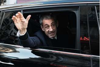 O ex-presidente francês Nicolas Sarkozy acena para seus apoiadores ao deixar sua residência para se apresentar à Prisão de La Santé para cumprir uma pena de cinco anos de prisão