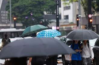 Pedestres caminham com guarda-chuva na Av. Paulista