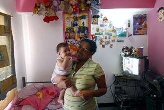 Marisol Aponte, 49 anos, posa para foto com o filho em sua casa