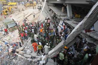 Equipes de emergência procuram por mortos e feridos sob os escombros do prédio que desabou