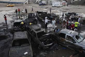 Moradores observam carros destruídos nas explosões em Bagdá