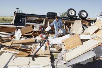 Mikie Hooper recolhe o que restou de casa destruída por um tornado em El Reno, Oklahoma, EUA, neste sábado