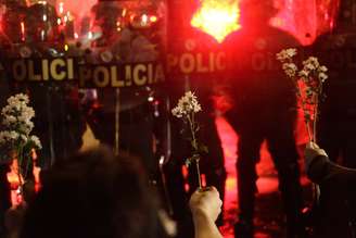 <p>Manifestantes oferecem flores à PM, que respondeu com bombas de gás e balas de borracha</p>