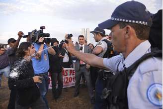 Policial usa spray de pimenta para tentar dispersar manifestantes em acampamento no gramado da Esplanada dos Ministérios