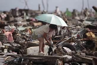 Em meio aos destroos, sobrevivente tenta resgatar pertences em Tacloban