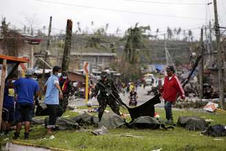 Soldados e policiais removem cadáveres a céu aberto na cidade de Tacloban