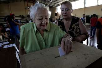 Mulher deposita voto em urna de seção eleitoral em Santiago