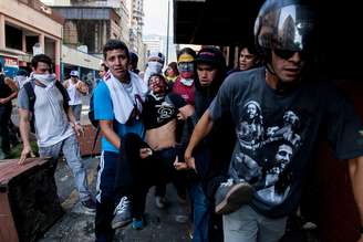 Estudante ferido é socorrido por manifestantes em Caracas