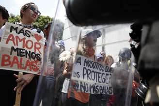 Manifestantes seguram placas e cartazes durante protesto contra o governo, em Caracas