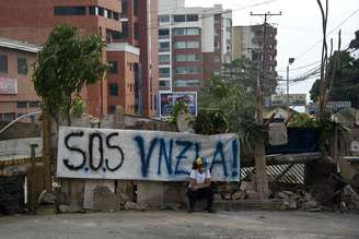 Mulher venezuelana sentada em rua bloqueada em San Cristobal, capital do estado de Tachira, em 23 fevereiro