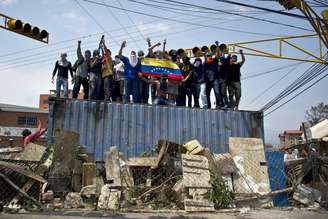 <p>Manifestantes sobem em um contêiner, usado como barricada em uma rua de San Cristóbal, capital do estado de Tachira, na Venezuela</p>