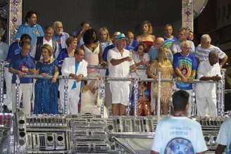 <p>Laura Cardoso desfila ao lado de Luis Fernando Guimar&atilde;es, que usa chap&eacute;u azul</p>