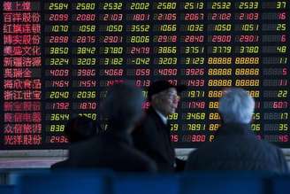 <p>Investidores observam informações exibidas em um painel eletrônico em uma corretora, em Xangai</p>