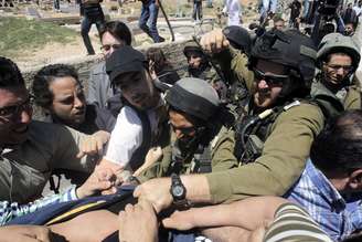<p>Soldados israelenses brigam com manifestantes perto de uma casa disputada por colonos israelenses e palestinos, na cidade de Hebron, em 11 de abril</p>