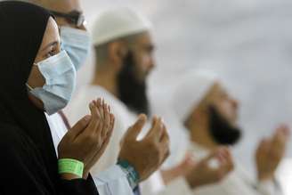 <p>Peregrinos usam máscaras como precaução contra a síndrome respiratória Oriente Médio durante oração, perto da cidade sagrada muçulmana de Meca, na Arábia Saudita</p>