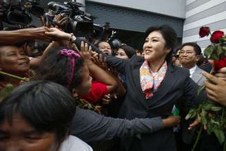 <p>A primeira-ministra da Tailândia, Yingluck Shinawatra, cumprimenta seus partidários ao sair do Escritório de Defesa de Bangock, em 7 de maio</p>