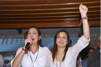 <p>Líder da oposição e ex-parlamentar Maria Corina Machado (à esquerda) e candidata a prefeita Patricia Gutierrez cumprimentam eleitores em um comício de campanha em San Cristobal, Venezuela, em 22 de maio</p>