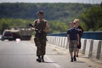 <p>Um militante separatista pró-russo é visto caminhando ao lado de sua família em uma rodovia em Lugansk, no leste ucraniano</p>