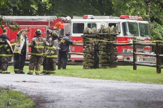 <p>Policiais e bombeiros participam de uma operação de resgate após a queda do pequeno avião que levava um bisneto do magnata do petróleo John D. Rockefeller</p>