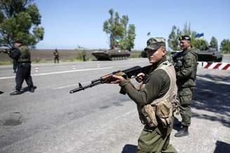 <p>O Exército informou que recuperou o controle da cidade de Mariupol. Na foto, um soldado ucraniano aponta sua arma em um posto de controle do Exército na cidade portuária, em 11 de maio</p>