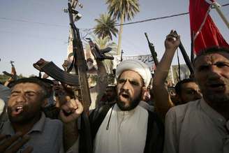 Combatentes tribais carregam armas durante uma marcha em Kerbala, no sul de Bagdá, no Iraque, nesta quarta-feira. 18/06/2014