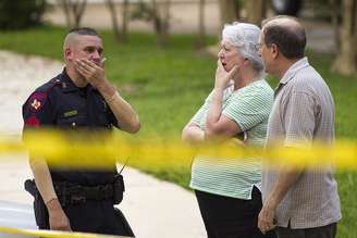 <p>Vizinhos observam cena do tiroteio ao lado de policiais, no Texas</p>