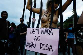Manifestante tira a roupa durante protesto em SP. Ela escreve no corpo a frase isso não é um convite