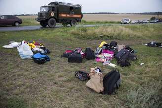 <p>Bagagem dos passageiros é recolhida no local onde o avião de passageiros da Malaysia Airlines caiu perto da aldeia de Rozsypne, no leste da Ucrânia, nesta quinta-feira, 17 de julho</p>