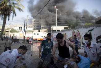 <p>Equipes de resgate atendem um homem palestino ferido após um ataque aéreo israelense em um mercado no bairro Shejaiya, perto da Cidade de Gaza, em 30 de julho</p>