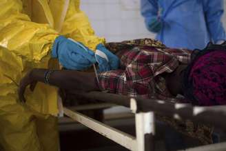 <p>Equipes médicas extraem amostra de sangue de um paciente suspeito de estar infectado com o vírus Ebola, no hospital estatal em Kenema, Serra Leoa</p>