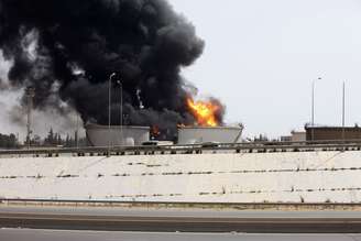 <p>Incêndio provocado pelo confronto entre milícias rivais em um depósito de combustível perto da estrada do aeroporto em Trípoli, em 29 de julho </p>