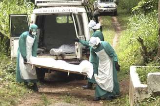 <p>Funcionários da área médica carregam corpo de vítima do Ebola em Serra Leoa, em 25 de julho</p>