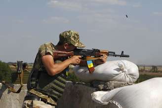 <p>Um militar ucraniano dispara seu rifle para verificar sua precisão, em um posto de controle perto da cidade de Debaltseve, na região de Donetsk, em 2 de agosto</p>