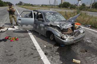 <p>Um soldado ucraniano é visto ao lado de um carro destruído em um posto de controle perto de Donetsk, nesta segunda-feira, 11 de agosto</p>