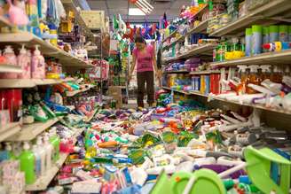 <p>A funcionária de um supermercado se depara com as prateleiras do estabelecimento totalmente desorganizadas após o terremoto que atingiu a cidade neste domingo</p>