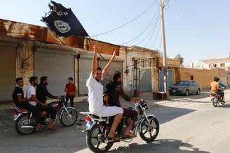 <p>Moradores de Tabqa erguem bandeira do Estado Islâmico perto de Raqqa</p>
