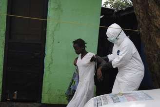 <p>Agente de saúde ajuda paciente com ebola na Libéria</p>