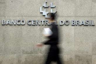 <p>Homem passa pela logomarca do Banco Central na sede do banco em Brasí­lia</p>