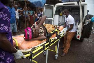 <p>Mulher grávida com suspeita de estar com ebola é levada para ambulância em Freetown</p>