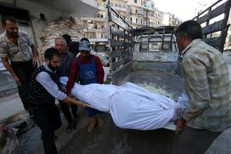 Homens carregam corpo de um morto durante conflitos em Aleppo